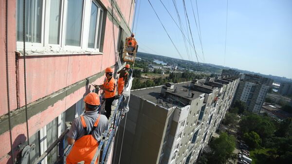 абочие проводят ремонт жилого дома в московском районе Капотня