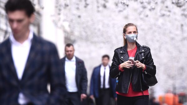 Девушка в защитной маске на Никольской улице в Москве
