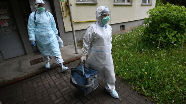 Медицинские работники во время визита к пациентам, контактировавшим с заболевшими коронавирусом, в Минске