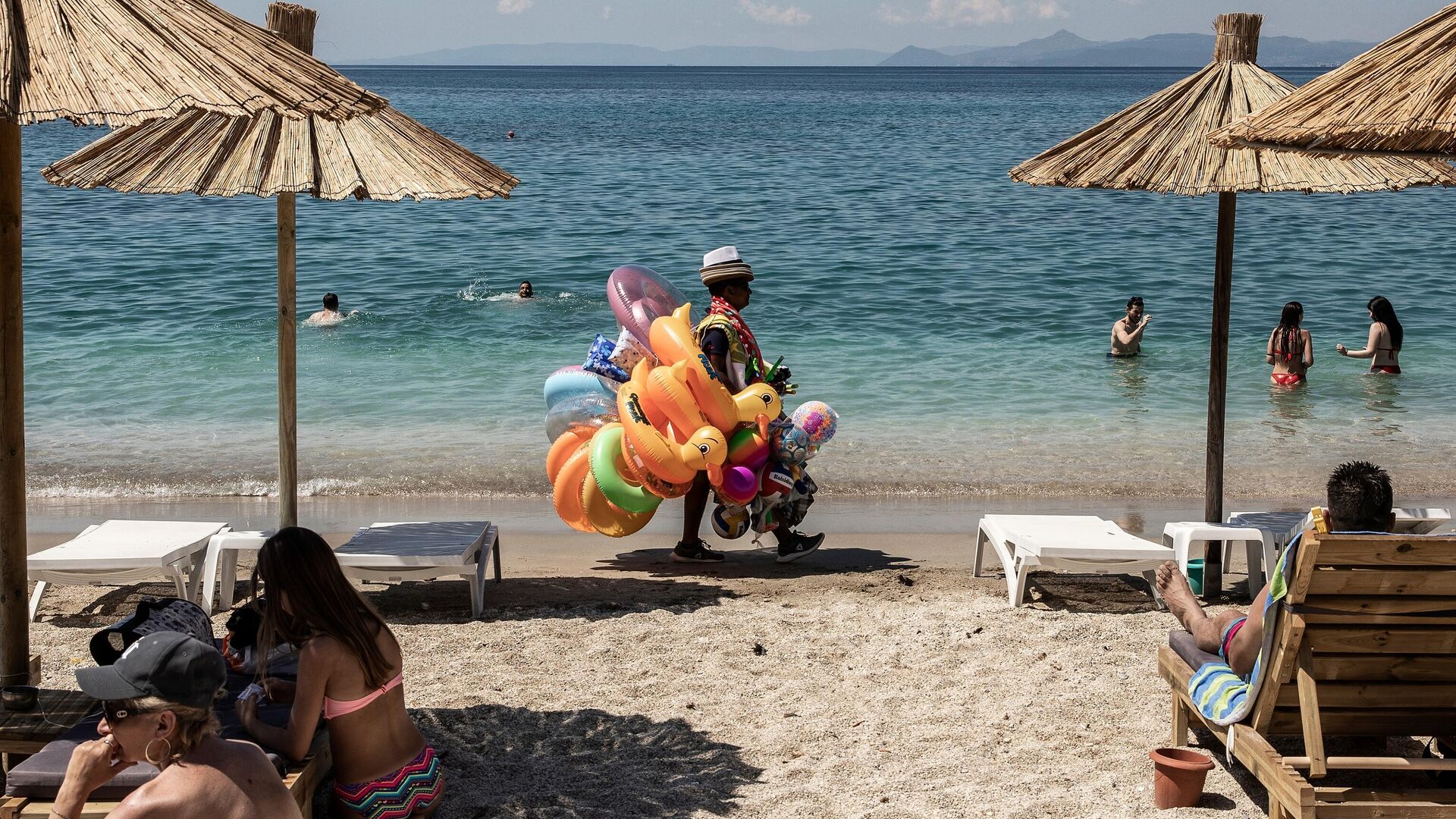 Отдыхающие и продавец игрушек на городском пляже Алимос в пригороде Афин - РИА Новости, 1920, 28.05.2020