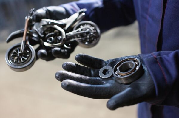 Мастер Станислав Черновасиленко выбирает подходящие по размеру подшипник и шайбу для будущего колеса миниатюрной копии мотоцикла