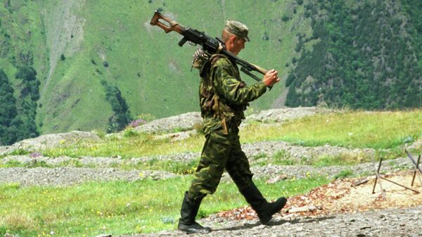 Пограничник Итум-Калинского отряда, охраняющего чеченский участок российско-грузинской границы, идет с пулеметом на боевое дежурство