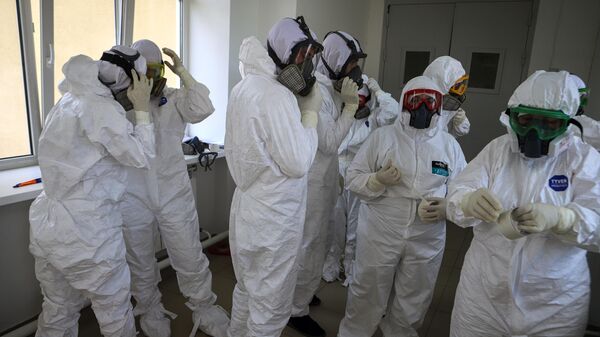 Медицинские работники одевают средства индивидуальной защиты перед входом в красную зону в госпитале для зараженных коронавирусной инфекцией COVID-19 в Черкесске