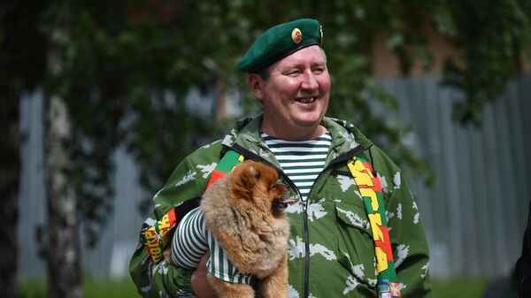 Пограничник в запасе со своей собакой во время празднования Дня пограничных войск возле сквера 40-летия Победы в Новосибирске