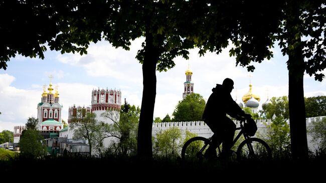 Мужчина катается на велосипеде в сквере у Новодевичьего женского монастыря в Москве