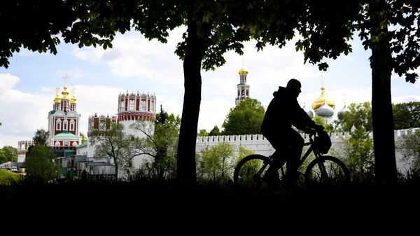 Мужчина катается на велосипеде в сквере у Новодевичьего женского монастыря в Москве