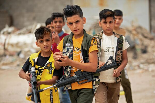 Дети играют с пластиковыми ружьями в Басре, Ирак