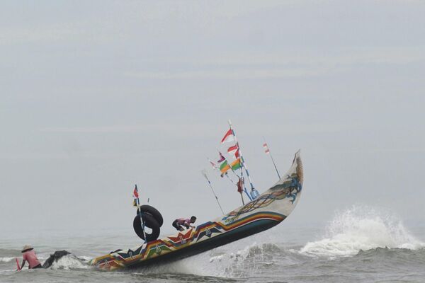 Рыбацкая лодка бьется о волны в Паданге, Суматра