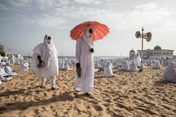 Члены общины Лайене на пляже перед мечетью Йоффа Лайена в Дакаре, Сенегал