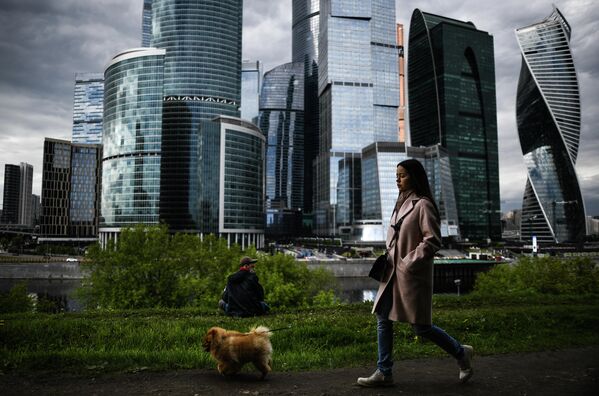 Девушка гуляет с собакой на набережной Тараса Шевченко в Москве