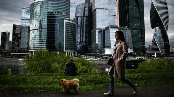 Девушка гуляет с собакой на набережной Тараса Шевченко в Москве