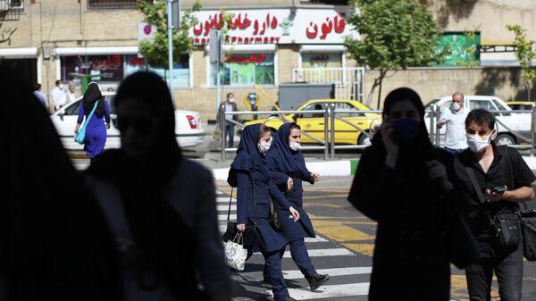 Прохожие в защитных масках на улице Тегерана 