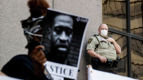 Участники акции протеста с портретом Джорджа Флойда у здания муниципалитета в Миннеаполисе