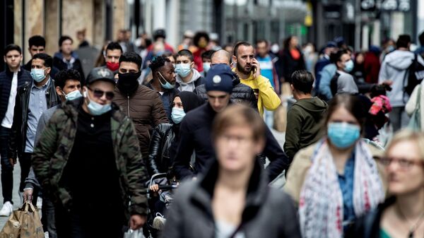 Люди гуляют по главной торговой улице Рю Нев в центре Брюсселя. 16 мая 2020 год
