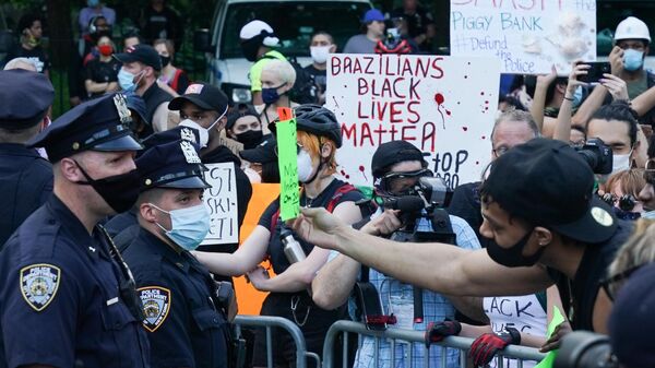 Полицейские стоят в оцеплении во время протеста, вызванного смертью афроамериканца Джорджа Флойда, на одной из улиц Нью-Йорка