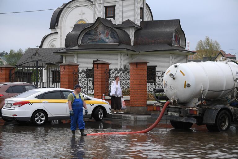 Ассенизаторская машина откачивает воду в поселке Нахабино Московской области