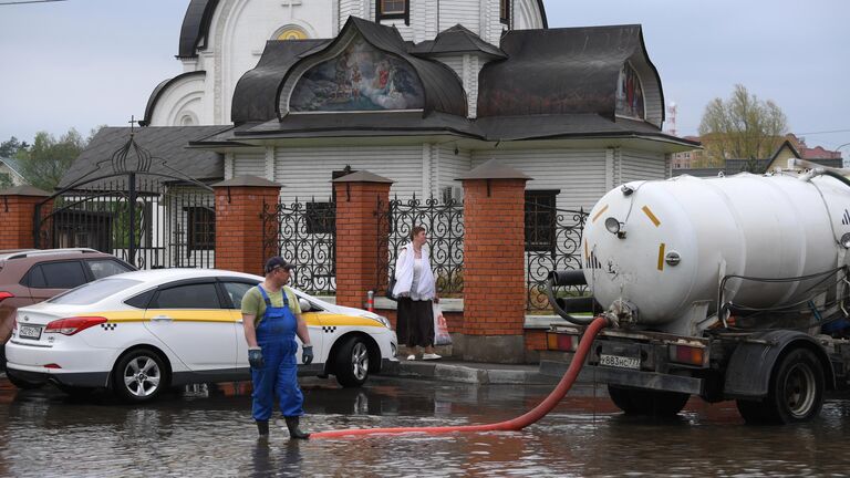 Ассенизаторская машина откачивает воду в поселке Нахабино Московской области