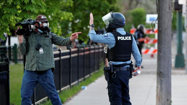 Журналист и сотрудник полиции во время акции протеста в Миннеаполисе, США