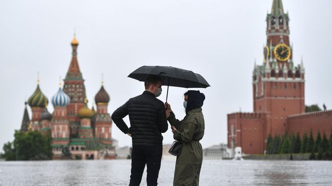 Прохожие во время дождя на Красной площади в Москве