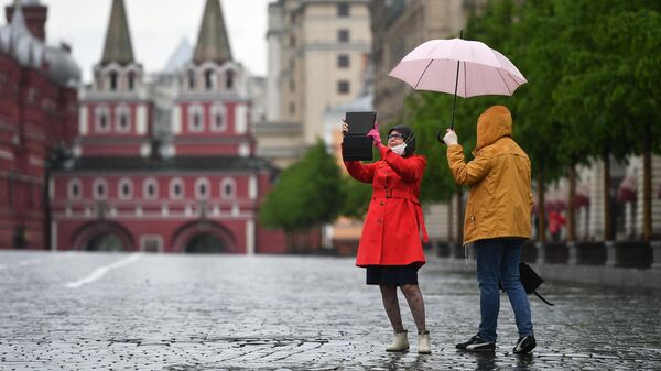 Прохожие во время дождя на Красной площади в Москве