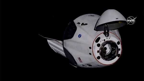 Американский корабль Crew Dragon компании SpaceX с астронавтами НАСА на борту во время стыковки с Межународной космической станцией. Стоп-кадр трансляции