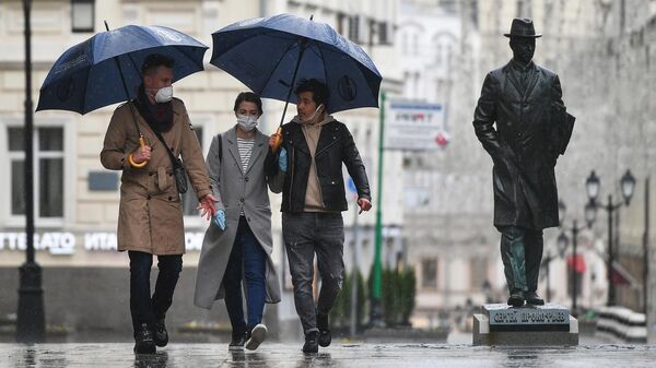 Прохожие во время дождя в Камергерском переулке в Москве