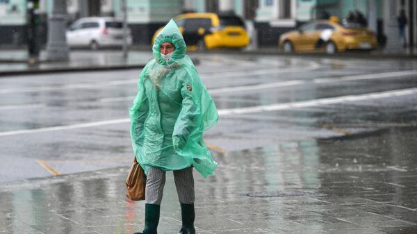 Женщина во время дождя на площади Белорусского вокзала в Москве