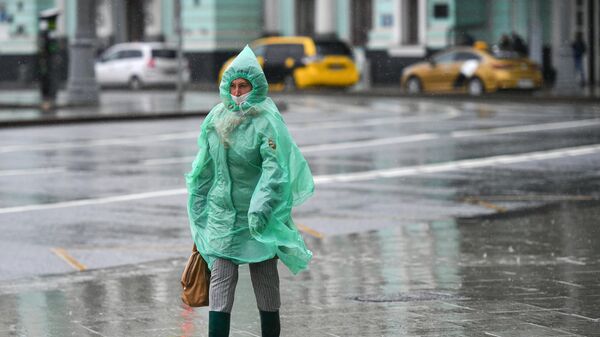 Женщина во время дождя на площади Белорусского вокзала в Москве