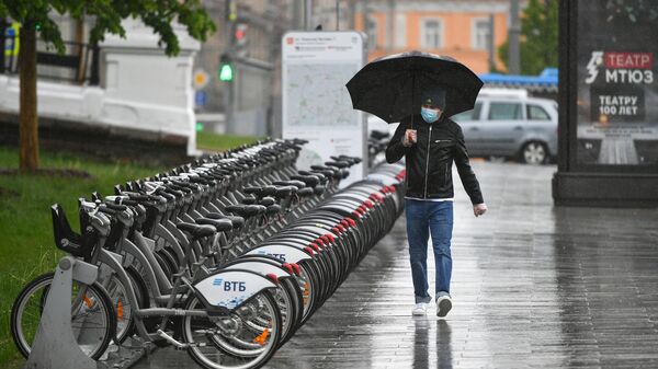 Прохожий во время дождя на площади Белорусского вокзала в Москве