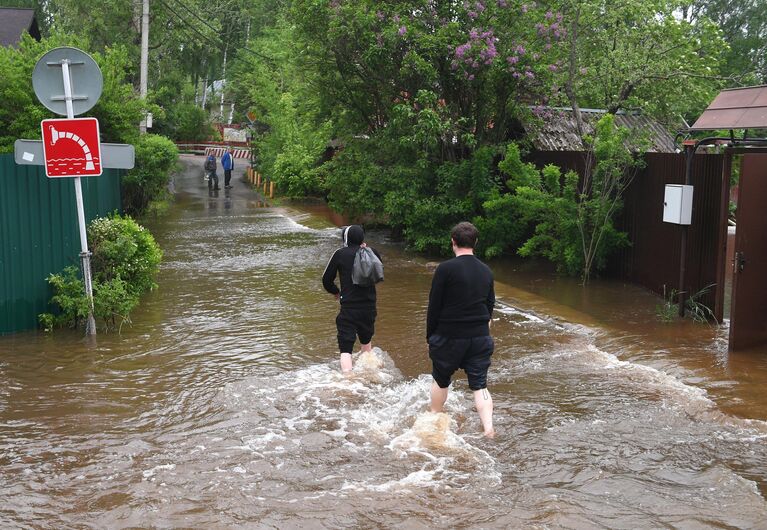 Люди на подтопленной улице в поселке Нахабино Московской области