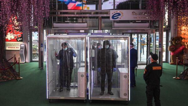Посетители проходят через кабины дезинфекции при входе в торговый центр Европейский, который  возобновил работу в рамках второго этапа снятия ограничений в Москве