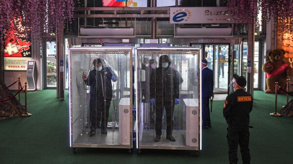 Посетители проходят через кабины дезинфекции при входе в торговый центр Европейский в Москве