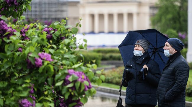 Прохожие гуляют на территории ВДНХ в Москве