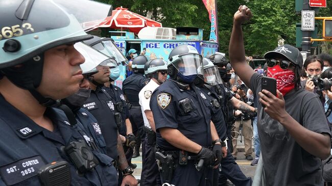 Полицейские стоят в оцеплении во время протестов на одной из улиц Нью-Йорка