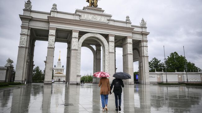 Прохожие у центрального входа на ВДНХ в Москве. ВДНХ вновь открылась для посещений в рамках второго этапа снятия ограничений в Москве, введенных для предотвращения распространения коронавируса