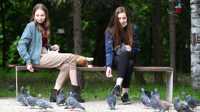 Девушки кормят голубей в парке имени Горького в Казани