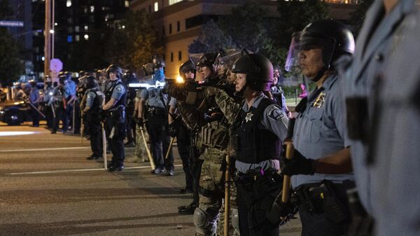 Сотрудники полиции и солдаты Национальной гвардии США выстроились в оцепление в Миннеаполисе после ареста протестующих