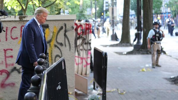 Президент США Дональд Трамп возле граффити, нарисованного протестующими в Вашингтоне 