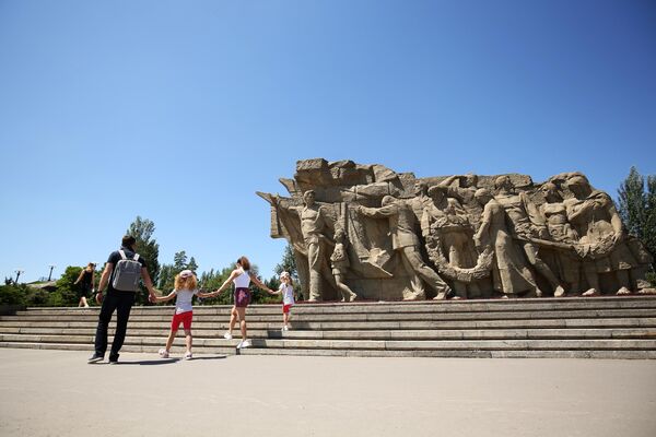 Посетители возле горельефа Память поколений на территории мемориального комплекса Героям Сталинградской битвы на Мамаевом кургане в Волгограде