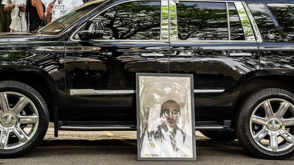 Портрет Джорджа Флойда, погибшего при задержании полицией 25 мая, у машины на церемонии прощания в Северном центральном университете в Миннеаполис