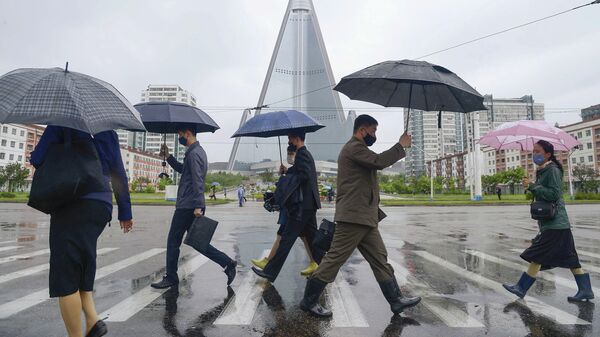 Прохожие в медицинских масках на улице Пхеньяна, КНДР