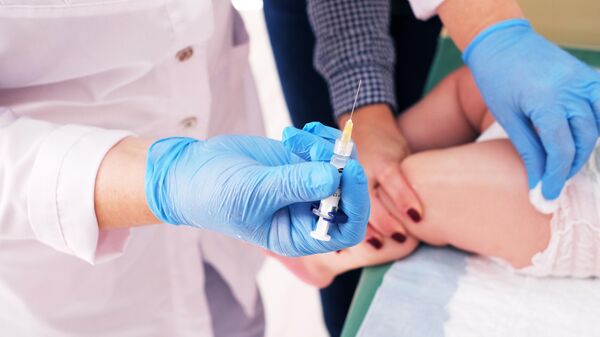 Медик делает прививку ребенку