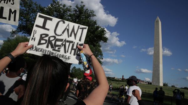 Протестующий с плакатом Я не могу дышать во время митинга возле памятника Вашингтону в США