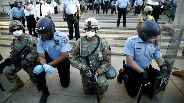 Сотрудники полиции и Национальной гвардии на коленях перед протестующими в Филадельфии, США