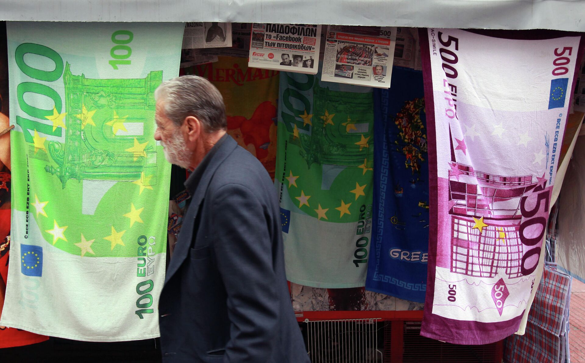 Ένας άντρας περνά δίπλα από ένα περίπτερο που πουλούσε πετσέτες με τη μορφή τραπεζογραμματίων ευρώ στην Αθήνα - RIA Novosti, 1920, 04/03/2023