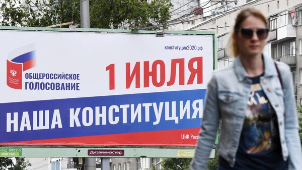 Прохожая около баннера, информирующего об общероссийском голосовании по поправкам в Конституцию РФ, в Новосибирске