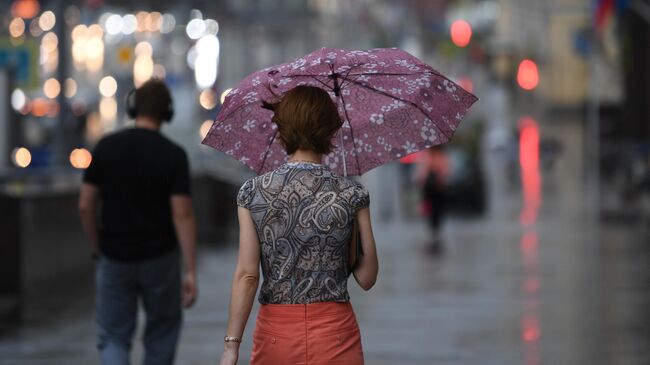 Девушка на одной из улиц в Москве во время дождя