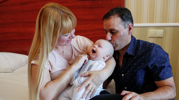 Супружеская пара из Аргентины во время церемонии передачи младенцев, рожденных суррогатными матерями, в киевском отеле Венеция