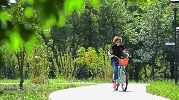 Девушка катается на велосипеде в парке Сад будущего в Москве