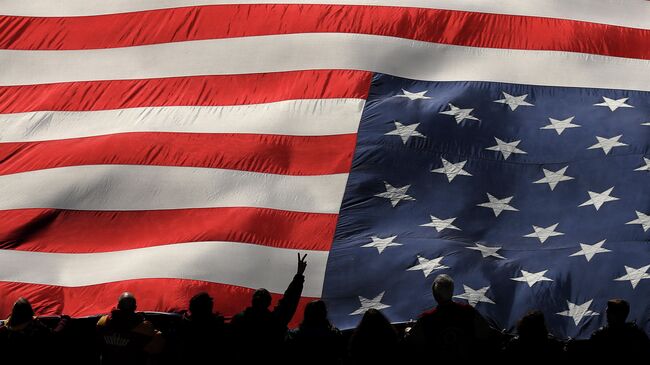 LANDOVER, MARYLAND - DECEMBER 15: A fan holds up the peace symbol with their hand as they hold an American flag before the Philadelphia Eagles play against the Washington Redskins at FedExField on December 15, 2019 in Landover, Maryland.   Patrick Smith/Getty Images/AFP